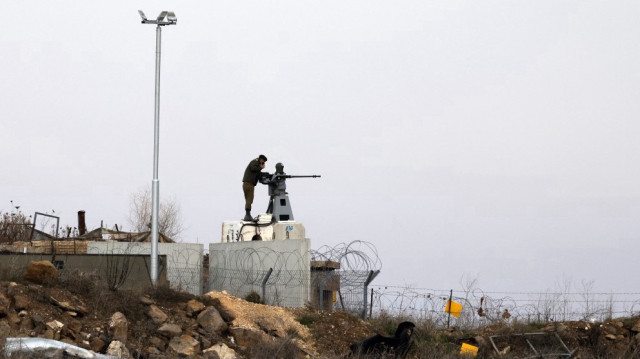Un soldat israélien se tient devant une mitrailleuse télécommandée sur le plateau du Golan annexé par Israël, à côté de la zone tampon contrôlée par l'ONU qui sépare les forces israéliennes et syriennes, près de la ville syrienne de Quneitra, le 5 janvier 2025.