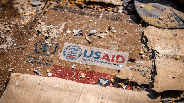 Un logo de l'USAID est visible sur une boîte au milieu des restes éparpillés de boîtes et de matériel laissés par les pilleurs après les actes de vandalisme et de pillage généralisés qui ont suivi les affrontements dans l'entrepôt du Programme alimentaire mondial (PAM) à Bukavu, le 21 février 2025.