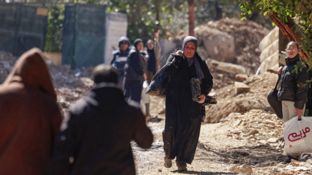 Des Palestiniens déplacés portent quelques affaires alors qu'ils marchent vers des zones plus sûres au milieu d'une offensive de plusieurs semaines de l'armée israélienne dans le camp de réfugiés de Jénine en Cisjordanie occupée, le 25 février 2025.