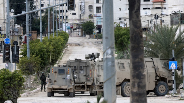 Les troupes israéliennes occupent une position à l'entrée du camp de réfugiés de Tulkarem, en Palestine occupée, lors d'un raid militaire le 21 février 2025.