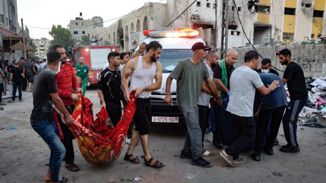 Des personnes enlèvent le corps d'une personne tuée lors d'une frappe israélienne sur une école dans la ville de Gaza, le 10 août 2024.