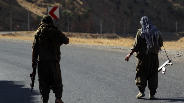 Un membre du Parti des travailleurs du Kurdistan (PKK) porte un fusil automatique sur une route dans les montagnes de Qandil, le quartier général du PKK dans le nord de l'Irak, le 22 juin 2018.