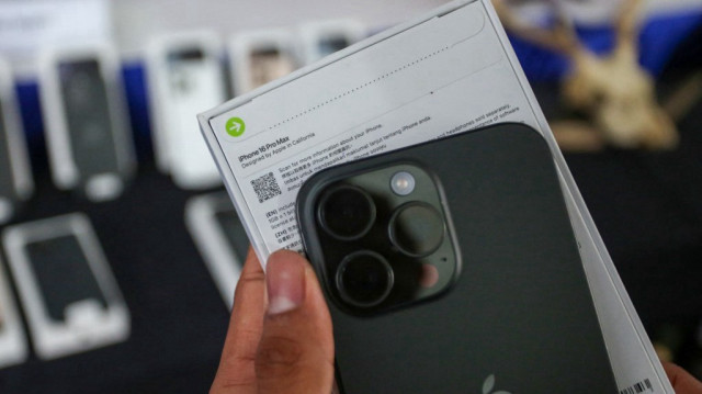 Un douanier indonésien montre un iPhone 16 Pro Max de contrebande avant de le détruire après qu'il a été confisqué avec des dizaines de téléphones et tablettes Apple, au bureau des douanes de l'aéroport international Soekarno-Hatta à Tangerang, Banten, le 29 novembre 2024.