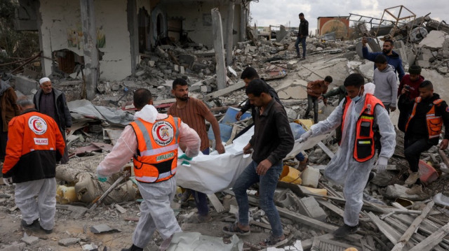 La défense civile palestinienne récupère un corps au milieu des décombres d'un quartier en ruine de la ville de Rafah, dans le sud de Gaza, le 22 janvier 2025.