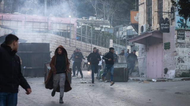 Des jeunes Palestiniens courent pour éviter les gaz lacrymogènes tirés par les forces israéliennes lors d'un raid dans la ville de Naplouse, le 25 février 2025.