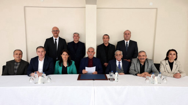 Le chef du PKK Abdullah Öcalan (première rangée, centre) posant avec les membres de la délégation du Parti pour l'Égalité et la Démocratie (DEM), à la prison de l'île d'Imrali, le 27 février 2025.