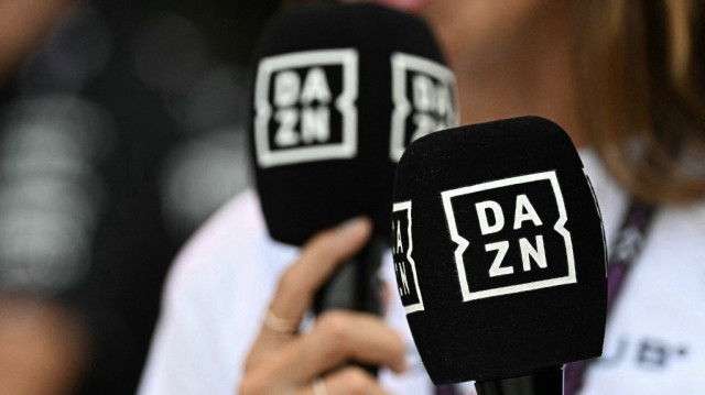 Un journaliste tient un micro de DAZN, la plateforme britannique de streaming et de divertissement sportif, à Monza, le 31 août 2024.