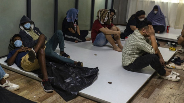 Des travailleurs et des victimes présumés de centres d'escroquerie se reposent lors d'une opération de répression des activités illicites menée par la Karen Border Guard Force (BGF) à Shwe Kokko, dans la commune orientale de Myawaddy (Myanmar), le 18 février 2025.