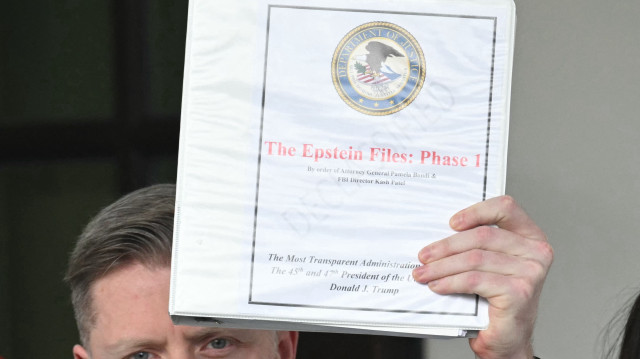 Le commentateur politique Rogan O'Handley, alias DC Draino, et d'autres personnes non identifiées portant des classeurs portant le sceau du ministère de la Justice des États-Unis et lisant "The Epstein Files : Phase 1" sortent de l'aile ouest de la Maison Blanche à Washington, DC, le 27 février 2025.