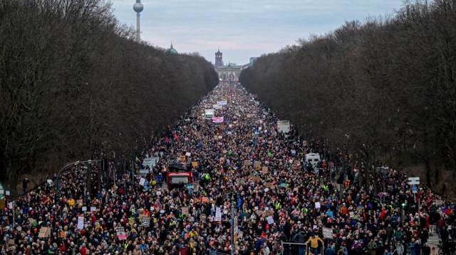 Des allemands participent à une manifestation contre l'extrême droite avec en arrière plan, la porte de Brandebourg, l'hôtel de ville Rotes Rathaus et la tour de télévision, à Berlin, le 2 février 2025.