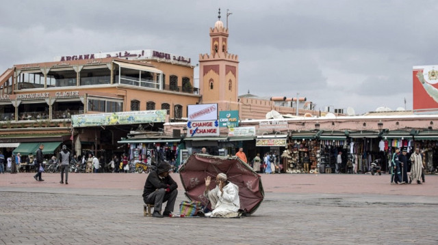 Des Marocains assis sur la place Jamaa el-Fna de Marrakech.