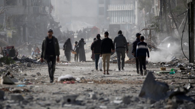Des Palestiniens marchent au milieu des décombres dans un quartier en ruine de la ville de Rafah à cause des bombardements de l'armée d'occupation israélienne, dans le sud de Gaza, le 20 janvier 2025, 