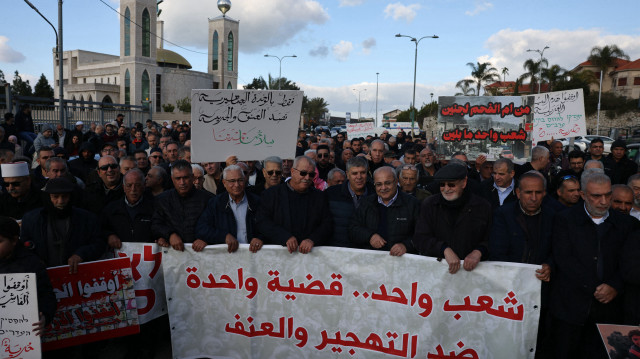Des Arabes israéliens portent des pancartes alors qu'ils manifestent contre le déplacement forcé des Palestiniens de Gaza, dans la ville arabe d'Umm al-Fahem, dans le nord du pays, le 8 février 2025.