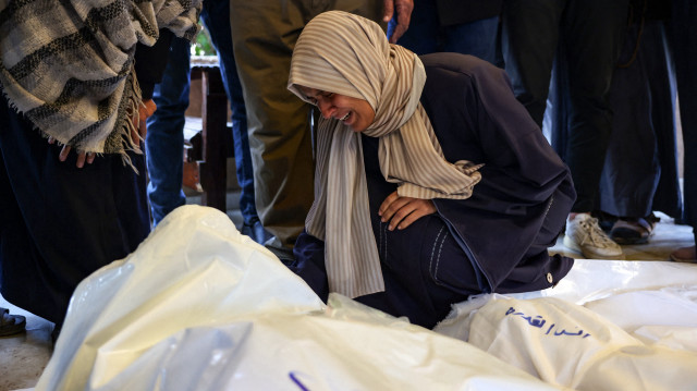Un parent pleure les corps des quatre membres de la famille palestinienne al-Qadra (les parents et leurs deux enfants) tués lors d'une frappe israélienne qui a touché leur tente au nord de Khan Yunis dans le sud de la bande de Gaza, dans la cour de l'hôpital Nasser, le 18 janvier 2025, un jour avant la mise en œuvre prévue d'un accord de cessez-le-feu entre Israël et le Hamas.