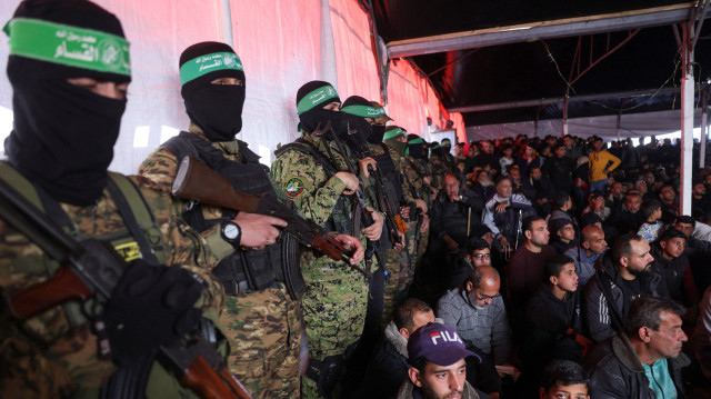 Des Palestiniens et des combattants du Hamas assistent à une cérémonie funéraire pour 40 militants et civils tués pendant la guerre avec Israël, dans le camp de réfugiés palestiniens de Shati, au nord de la ville de Gaza, le 28 février 2025, dans le cadre de l'accord de cessez-le-feu en vigueur dans le cadre de la guerre entre Israël et le Hamas.