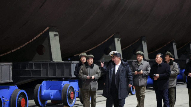 Cette photo non datée diffusée par l'agence de presse officielle nord-coréenne Korean Central News Agency (KCNA) via KNS le 8 mars 2025 montre le dirigeant nord-coréen Kim Jong Un (à l'avant, à droite) inspectant un projet de construction navale dans un grand chantier naval situé dans un lieu non divulgué en Corée du Nord.