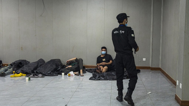 Des travailleurs et des victimes présumés de centres d'escroquerie se reposent lors d'une opération de répression des activités illicites menée par la Karen Border Guard Force (BGF) à Shwe Kokko, dans la commune orientale de Myawaddy (Myanmar), le 18 février 2025.