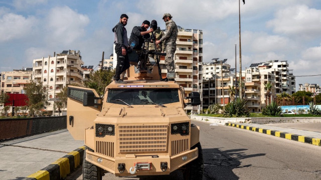 Les forces de sécurité loyales au gouvernement intérimaire syrien fixent une tourelle sur un véhicule blindé garé le long d'une route dans la ville de Lattaquié, à l'ouest de la Syrie, le 9 mars 2025.
