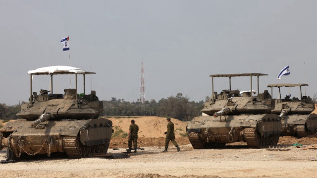 Des soldats de l'armée israélienne passent devant des chars à une position près de la frontière sud d'Israël avec la bande de Gaza, le 6 mars 2025.
