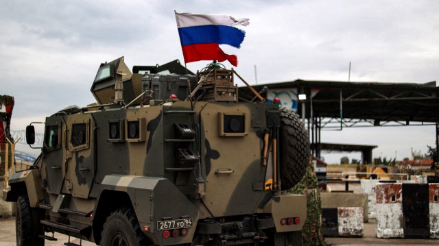 Un drapeau russe effiloché flotte sur un véhicule blindé.