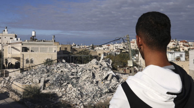 Un Palestinien regarde les restes d'une maison démolie par des bulldozers israéliens dans le village d'Idna, près de la ville d'Hébron en Palestine occupée, le 27 novembre 2024.