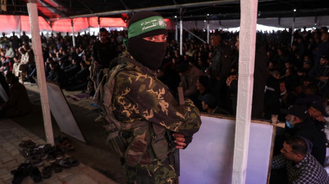 Un combattant du Hamas et des civils palestiniens assistent à une cérémonie funéraire en l'honneur de 40 militants et civils tués pendant la guerre avec Israël.