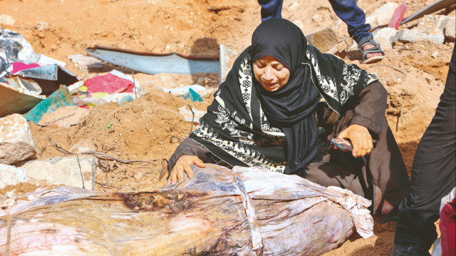 Filistinli sivil savunma görevlileri, İsrail’in katlettiği ve aylardır Şifa Hastanesi’nin arazisinde gömülü cenazeleri çıkarıyor. Bir kadın naaşına kavuştuğu yakınının başında ağladı.
