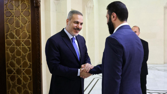 Cette photo diffusée par le service de presse du ministère turc des Affaires étrangères montre le ministre turc des Affaires étrangères Hakan Fidan (G) accueilli par le président intérimaire de la Syrie Ahmed al-Sharaa à Damas le 13 mars 2025. 