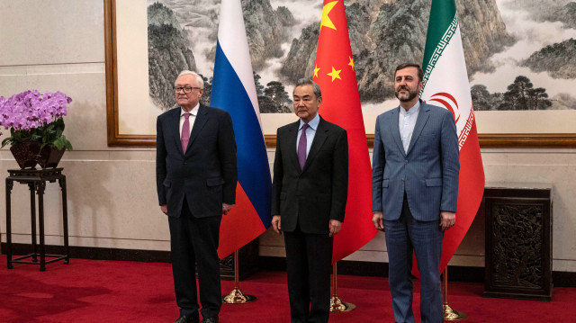 Le ministre chinois des affaires étrangères, Wang Yi (C), accueille le vice-ministre russe des affaires étrangères, Sergey Ryabkov (G), et le vice-ministre iranien des affaires étrangères, Kazeem Gharibabadi, avant une réunion sur la question nucléaire iranienne à la maison d'hôtes d'État Diaoyutai, à Pékin, le 14 mars 2025. La Chine a appelé à la levée des sanctions "illégales" contre l'Iran en accueillant des diplomates de ce pays et de la Russie le 14 mars pour des entretiens dont Pékin espère qu'ils permettront de relancer les négociations sur le programme nucléaire de Téhéran, qui sont depuis longtemps dans l'impasse.