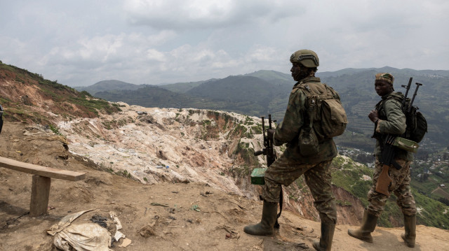 Des soldats du M23 se tiennent devant les puits miniers de Rubaya, le 5 mars 2025. Ravagé par un conflit depuis 30 ans, l'est de la RDC détiendrait entre 60 et 80 % des réserves mondiales de coltan, un minerai essentiel pour la fabrication d'équipements électroniques.