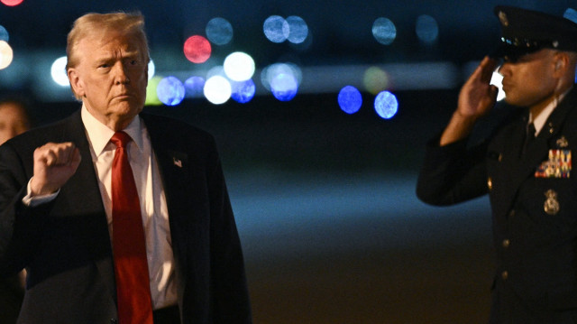 Le président américain Donald Trump fait un geste à son arrivée à l'aéroport international de Palm Beach à West Palm Beach, en Floride, le 14 mars 2025. 