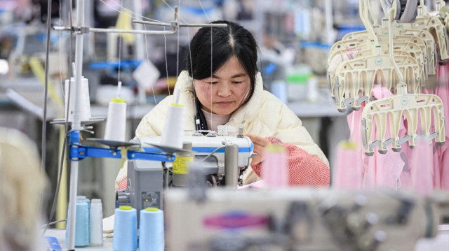 Un employé fabrique des vêtements dans une usine de Lianyungang, dans la province de Jiangsu, dans l'est de la Chine, le 13 mars 2025.
