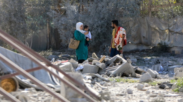 Des personnes marchent au milieu de débris après une frappe israélienne le jour précédent dans la ville de Daraa, dans le sud de la Syrie, le 18 mars 2025.