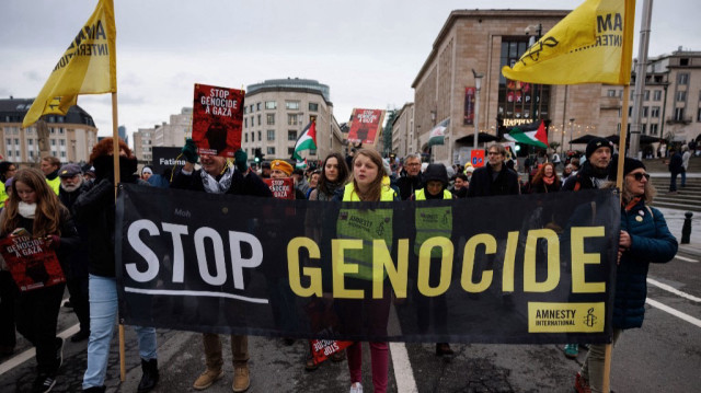 Des membres d'Amnesty International tiennent une banderole sur laquelle on peut lire ”Stop au génocide”'lors d'une manifestation organisée par une douzaine d'organisations pro-palestiniennes en soutien au peuple palestinien, à Bruxelles, le 26 janvier 2025.