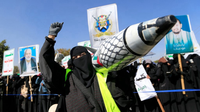 Une Yéménite brandit un faux missile décoré des couleurs du drapeau palestinien et du keffieh à damieri, lors d'une manifestation à Sanaa pour dénoncer les frappes sur le Yémen et le bombardement de Gaza par Israël, le 15 janvier 2025.