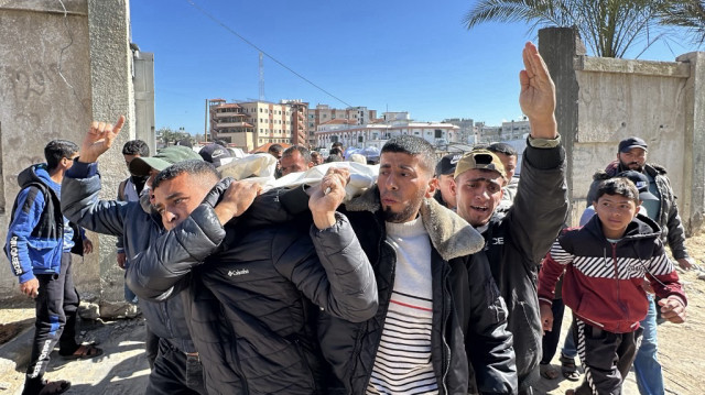 Des Palestiniens portent le corps d'un membre de leur famille, tué par des frappes israéliennes, lors de leurs funérailles à Khan Yunis, dans le sud de la bande de Gaza, le 23 mars 2025.