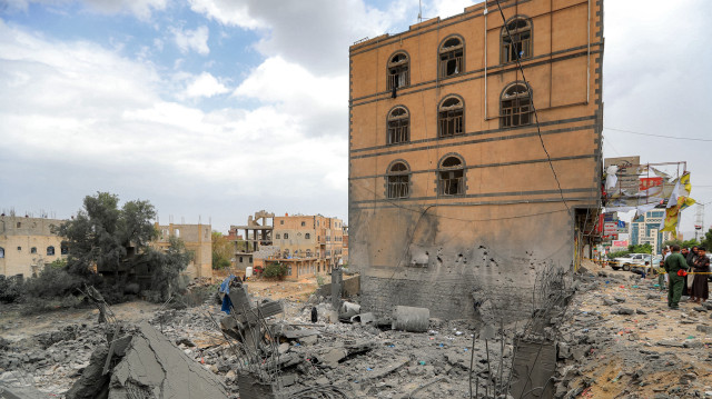 Des personnes se rassemblent près des décombres d'un bâtiment effondré sur le site d'une frappe aérienne américaine sur Sanaa, la capitale du Yémen tenue par les Houthis, le 24 mars 2025. Les rebelles houthis du Yémen ont déclaré qu'une personne avait été tuée et 13 autres blessées lors de frappes sur Sanaa le 23 mars en fin de journée.