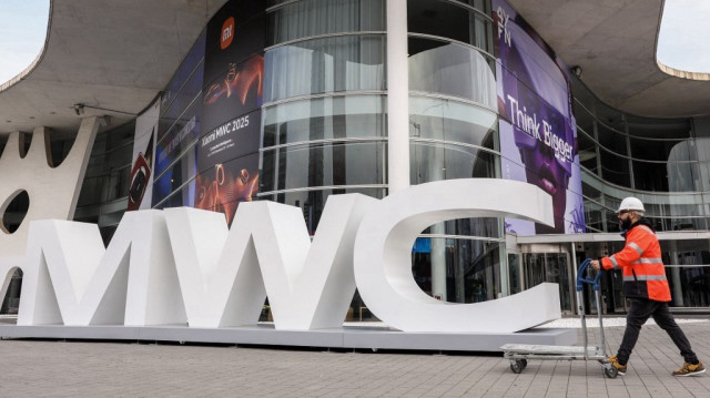 Un ouvrier passe devant l'entrée de la Fira Barcelona, où se tient le Mobile World Congress (MWC), le plus grand événement mondial en matière de connectivité, à Barcelone, le 27 février 2025.