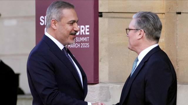 Le Premier ministre britannique Keir Starmer (à droite) salue le ministre turc des Affaires étrangères Hakan Fidan (à gauche) à son arrivée au sommet organisé à Lancaster House, dans le centre de Londres, le 2 mars 2025. 