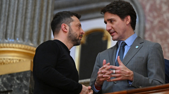 Le président ukrainien Volodymyr Zelensky (à gauche) et le Premier ministre canadien Justin Trudeau (à droite) discutent dans les escaliers alors qu'ils se rendent à une réunion plénière lors d'un sommet organisé à Lancaster House, dans le centre de Londres, le 2 mars 2025.