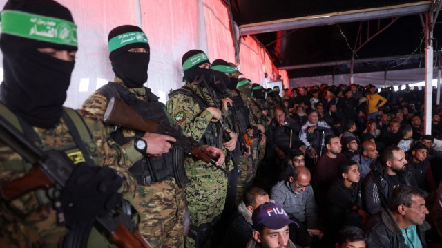 Des Palestiniens et des combattants du Hamas assistent à une cérémonie funéraire pour 40 militants et civils tués pendant la guerre avec Israël, au camp de Shati à Gaza, le 28 février 2025.