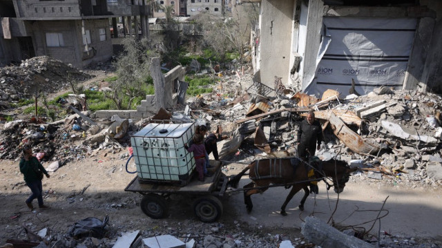 Un âne tire une charrette avec un réservoir d'eau potable pour la distribuer aux habitants de Jabalia, dans le nord de la bande de Gaza, le 17 février 2025.