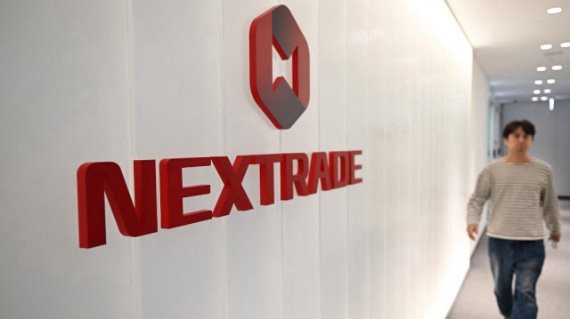 Un homme passe devant un panneau de "Nextrade", la deuxième plateforme boursière de Corée du Sud, dans ses bureaux de Séoul, le 4 mars 2025.