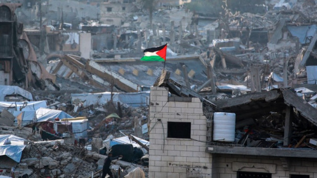 Une bannière palestinienne flotte parmi les ruines des bâtiments à Beit Lahia, dans le nord de la bande de Gaza, le 4 mars 2025.