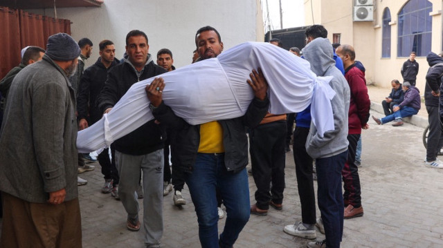 Un homme porte le corps enveloppé d'une personne tuée lors de frappes israéliennes dans la ville de Gaza la nuit précédente, à l'hôpital Al-Ahli Arab.