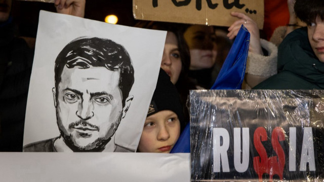Un garçon tient un portrait du président ukrainien Volodymyr Zelensky devant l'ambassade des États-Unis à Varsovie, le 3 mars 2025.