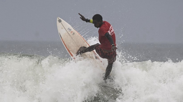 Souleymane Sidibé, de Côte d'Ivoire, participe à l'Africa Surf Tour 2025 sur la plage d'Assinie, le 22 février 2025.