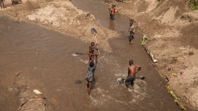 Des enfants, qui font partie des habitants qui sont retournés dans leur village, extraient du sable de la rivière Renga à Bweremane, le 27 février 2025.