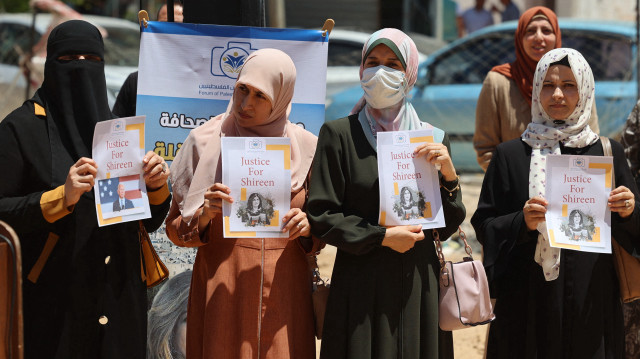 Des journalistes palestiniens se rassemblent lors d'une manifestation demandant justice pour la journaliste d'Al Jazeera Shireen Abu Akleh, tuée alors qu'elle couvrait un raid de l'armée israélienne à Jénine en mai, devant les décombres de la tour Al-Jalaa, rasée par une frappe aérienne israélienne lors du conflit de l'année dernière, dans la ville de Gaza, le 13 juillet 2022, avant l'arrivée du président américain Joe Biden pour une visite officielle.