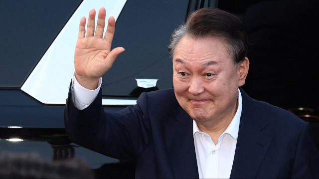 Le président sud-coréen Yoon Suk Yeol réagit à ses partisans à son arrivée à la résidence présidentielle à Séoul, le 8 mars 2025. Le président sud-coréen destitué Yoon Suk Yeol a été remis en liberté le 8 mars, après qu'un tribunal a annulé son arrestation pour des raisons de procédure, mais il fait toujours l'objet d'une enquête concernant sa déclaration de la loi martiale.
